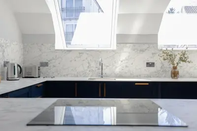 a kitchen with blue cabinets and a sink at Old Church Apartment 4 in Oban