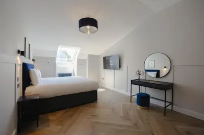 a bedroom with a bed and a mirror and a table at Old Church Apartment 4 in Oban