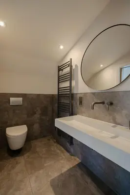 a bathroom with a sink and a toilet and a mirror at Old Church Apartment 4 in Oban