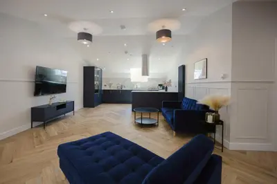 a living room with a blue couch and a tv at Old Church Apartment 5 in Oban