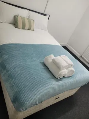a bed with two towels sitting on top of it at Akwaaba services in Moffat