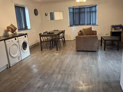 a living room with a table and a washing machine at Akwaaba services in Moffat