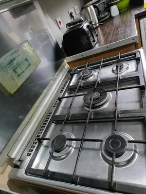 a stove top with four burners in a kitchen at Akwaaba services in Moffat