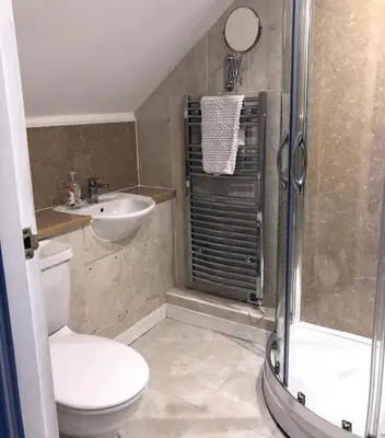 a bathroom with a toilet and a sink and a shower at Glenalbyn Cottage in Saint Fillans