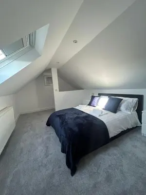 a bedroom with a large bed in a attic at Plains Town House, Airdrie in Caldercruix