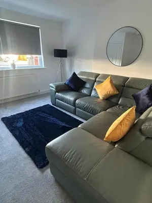 a living room with a couch and a mirror at Plains Town House, Airdrie in Caldercruix