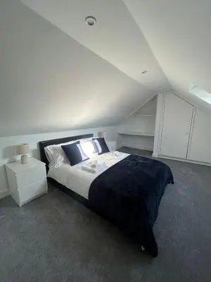 a bedroom with a large bed in a attic at Plains Town House, Airdrie in Caldercruix