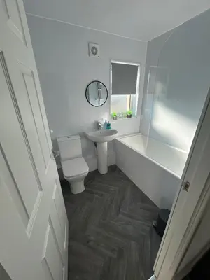 a white bathroom with a toilet and a sink at Plains Town House, Airdrie in Caldercruix