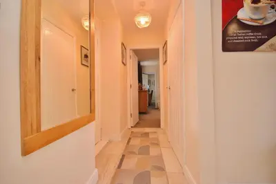 a hallway with a mirror on the wall and a hallwayngth at Peaceful Village Flat 2 Bedrooms in Douglas
