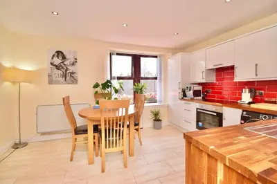 a kitchen and dining room with a table and chairs at Peaceful Village Flat 2 Bedrooms in Douglas
