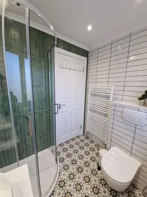 a bathroom with a toilet and a glass shower at Justina's House in East Kilbride