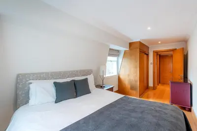 a bedroom with a large bed and a television at Knightsbridge Duplex Two Bedroom Apartment in Moffat