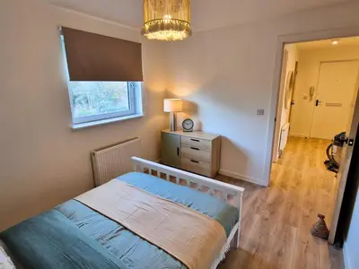 a bedroom with a bed and a dresser and a window at 7 min from Edinburgh Airport 2 Bedroom Apartment in Edinburgh