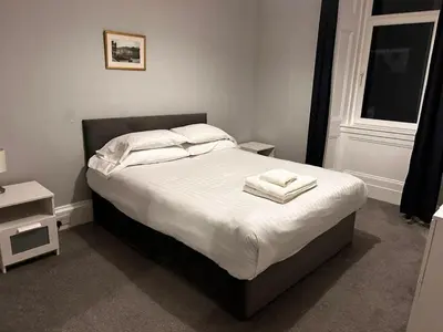 a bedroom with a bed with two towels on it at No 1 Westbay Apartment in Dunollie