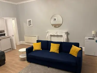 a blue couch with yellow pillows in a living room at No 1 Westbay Apartment in Dunollie