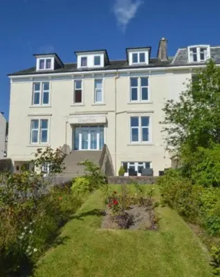 a large white building with a garden in front of it at No 1 Westbay Apartment in Dunollie
