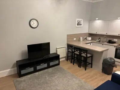 a kitchen with a table and a clock on the wall at No 1 Westbay Apartment in Dunollie