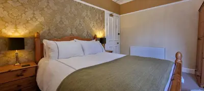 a bedroom with a large white bed in a room at Craigbuie Guesthouse in Killin