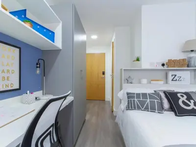 a bedroom with a large white bed and a desk at Collegelands in Glasgow in Glasgow