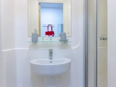 a white bathroom with a sink and a mirror at Collegelands in Glasgow in Glasgow