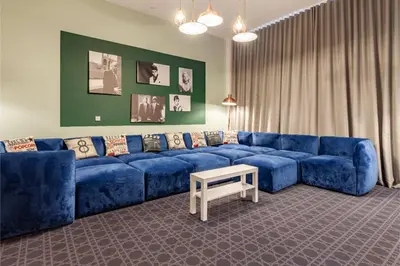 a living room with a blue couch and a table at Collegelands in Glasgow in Glasgow