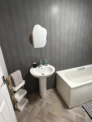 a bathroom with a sink and a toilet and a tub and a sink at 3BR Home Sleeps 10 with Private Drive Near Park in Newton Mearns