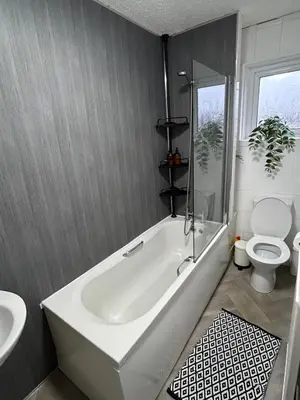 a bathroom with a white tub and a toilet at 3BR Home Sleeps 10 with Private Drive Near Park in Newton Mearns