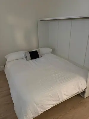 a white bed in a room with white walls at Castle flat in Edinburgh in Edinburgh