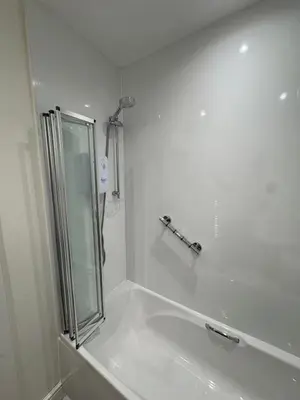 a white bathroom with a shower and a sink at Castle flat in Edinburgh in Edinburgh