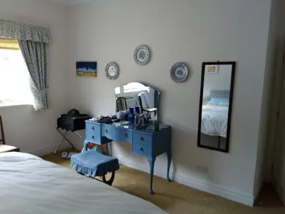 a bedroom with a blue dresser and a mirror at Sevenacres Kelso in Moffat