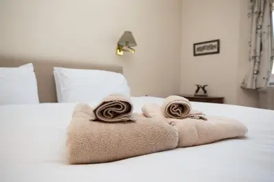 a pair of towels sitting on top of a bed at Sevenacres Kelso in Moffat