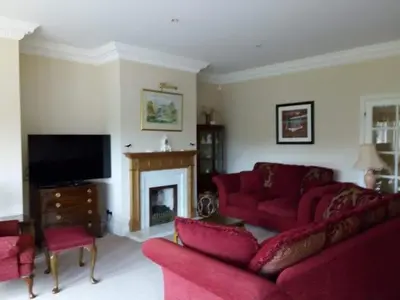 a living room with red couches and a fireplace at Sevenacres Kelso in Moffat