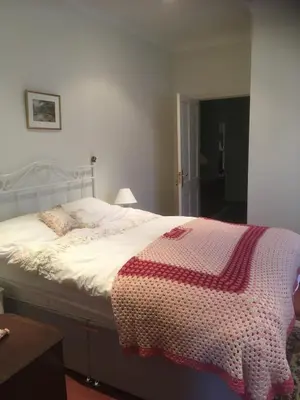 a bedroom with a bed with a red and white blanket at Sevenacres Kelso in Moffat