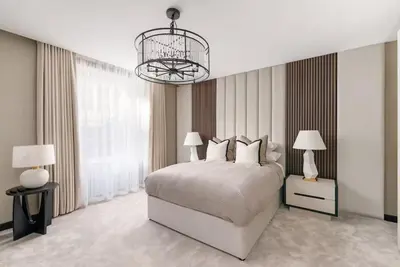 a bedroom with a large bed and a chandelier at Near Transport - Hot tub - Fireplace - Sleeps 2 in Edinburgh