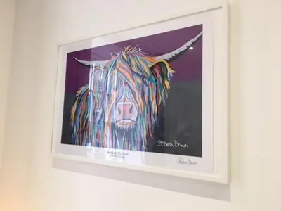 a painting of a cow on a wall at Heart Of Edinburgh City Flat in Edinburgh