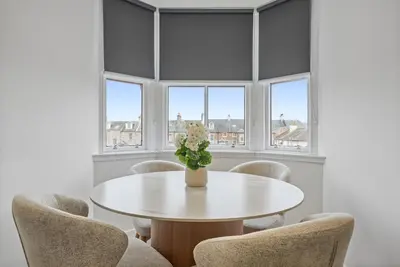 a dining room with a white table and chairs at The Penthouse - Beachwalk Apartments in Ayr