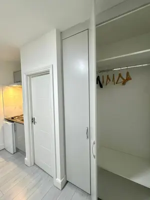 a white closet with a door in a room at Cozy Golders Green Studio Flat in Moffat