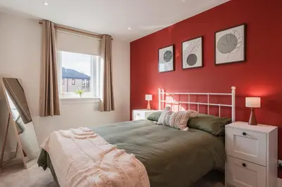 a bedroom with red walls and a bed and a window at Henderson House - West End 3 Bedroom Family Home in Glasgow