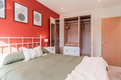 a bedroom with a bed with a red wall at Henderson House - West End 3 Bedroom Family Home in Glasgow