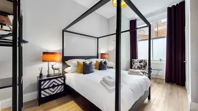 a bedroom with a black and white canopy bed at The Steamie on Bath St in Glasgow