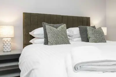 a bedroom with a white bed with pillows at The Sauchie in Glasgow