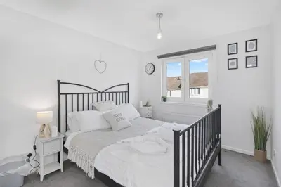 a bedroom with a black and white bed and a window at Cozy Edinburgh 2BR with CAR parking in Edinburgh