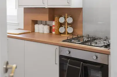 a kitchen with a stove and a counter top at Cozy Edinburgh 2BR with CAR parking in Edinburgh