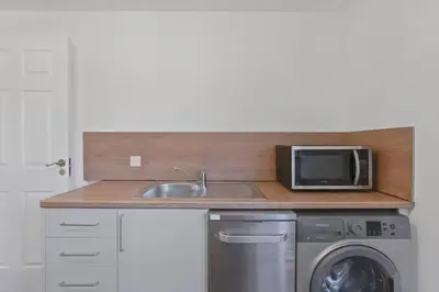a kitchen with a sink and a microwave at Cozy Edinburgh 2BR with CAR parking in Edinburgh