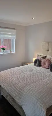 a bedroom with a large white bed with a window at Glenfern Guest House and a separate Cottage with its own private hot tub in Balloch