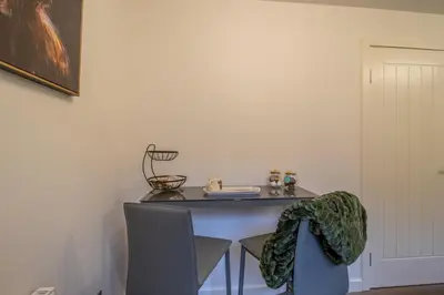 a table and chairs in a room with a table and a chair at Angel House - 3 bedrooms close to Airdrie Centre in Airdrie