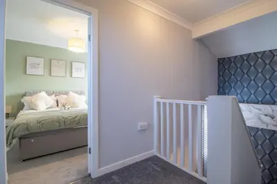 a bedroom with a bed with white pillows at Catriona House - 3 Bedroom house in Motherwell in Holytown
