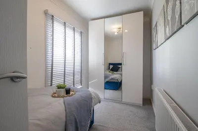 a bedroom with a bed and a mirror in it at Catriona House - 3 Bedroom house in Motherwell in Holytown