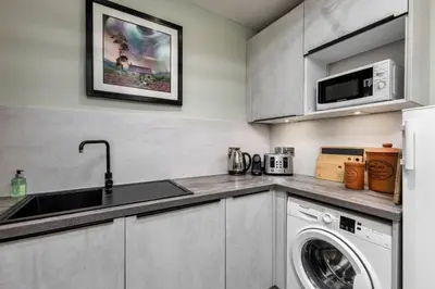 a kitchen with a sink and a washing machine at 3-Bed Georgian Townhouse Next to Wellbeing Clinic in Stirling