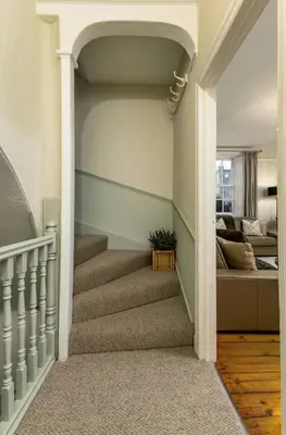 a hallway with stairs with a bed in the background at 3-Bed Georgian Townhouse Next to Wellbeing Clinic in Stirling